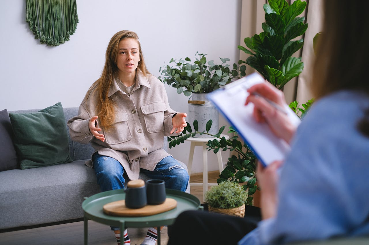 why-choose-us-img A woman engages in a therapy session, discussing issues with a counselor inside a modern office.